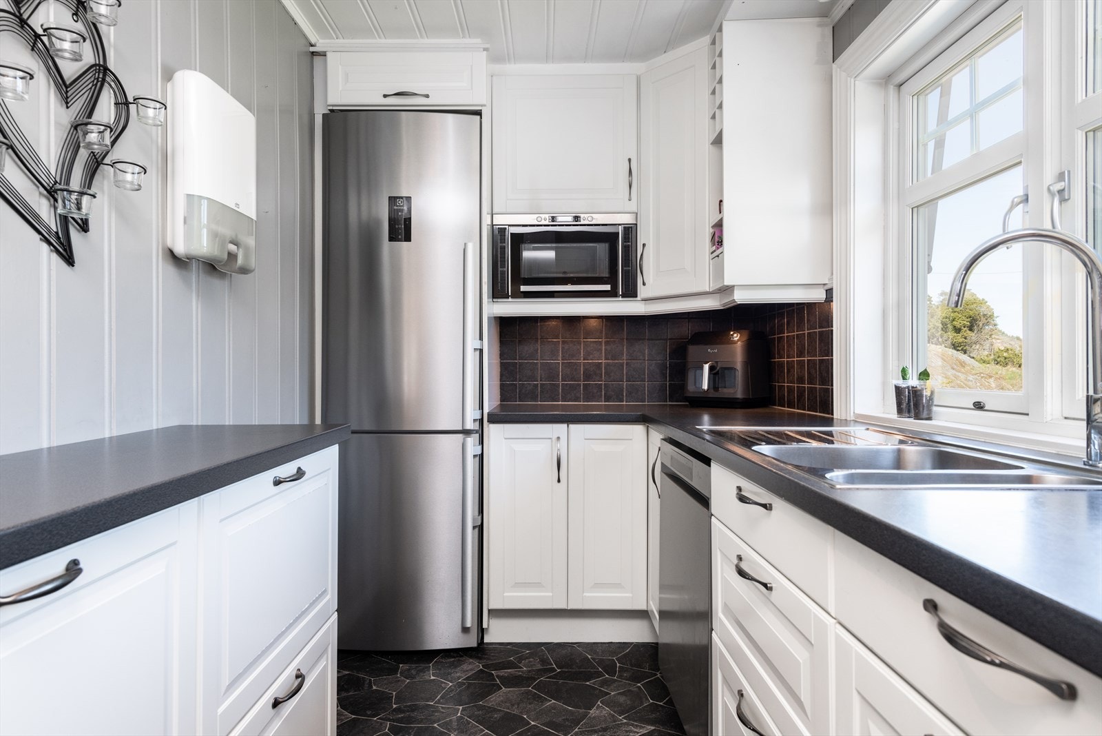 Lys, profiler kjøkkeninnredning med takhøye overskap. Galleribilde