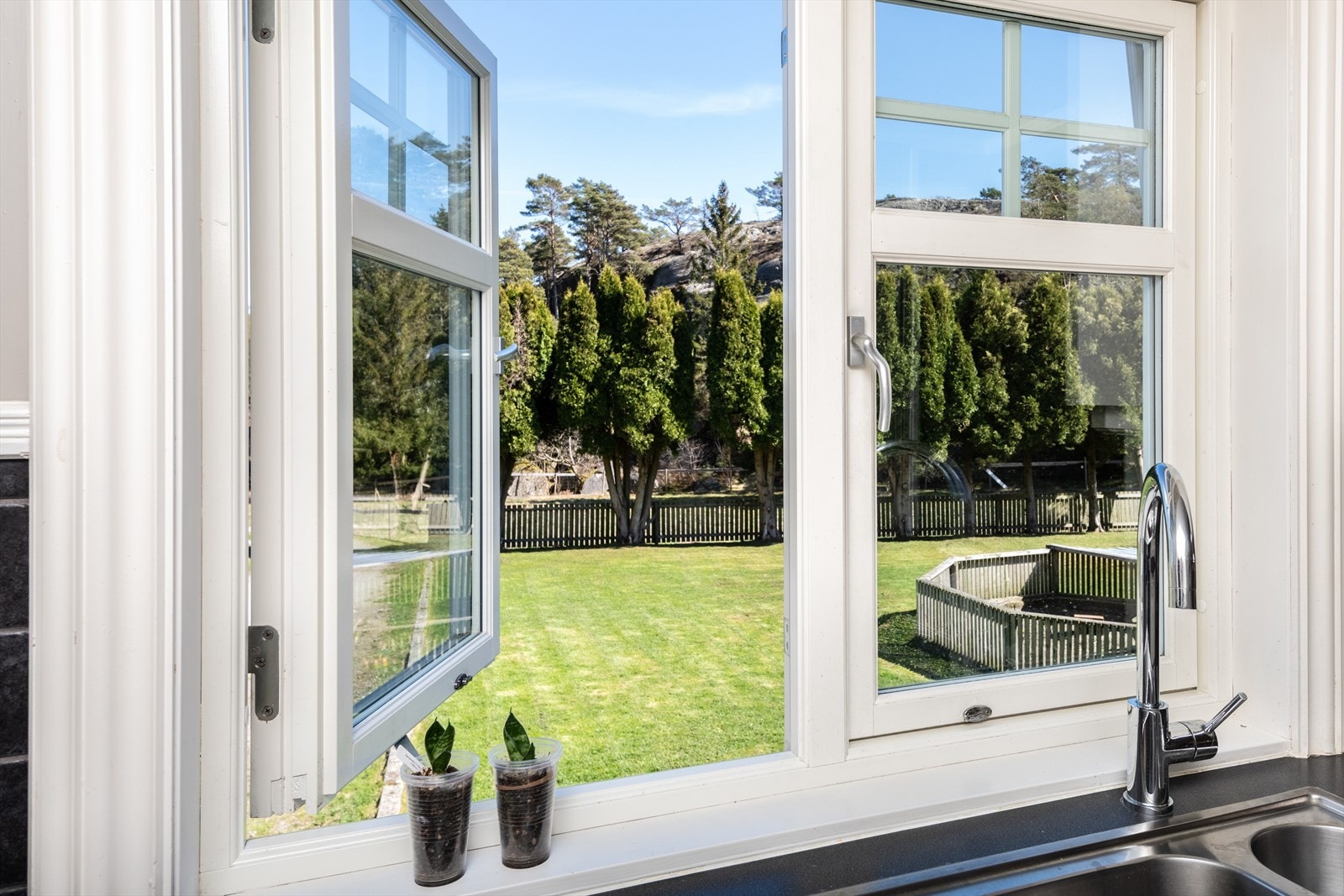 Fra kjøkkenvasken kan se ut over den solrike og usjenerte hagen. Galleribilde