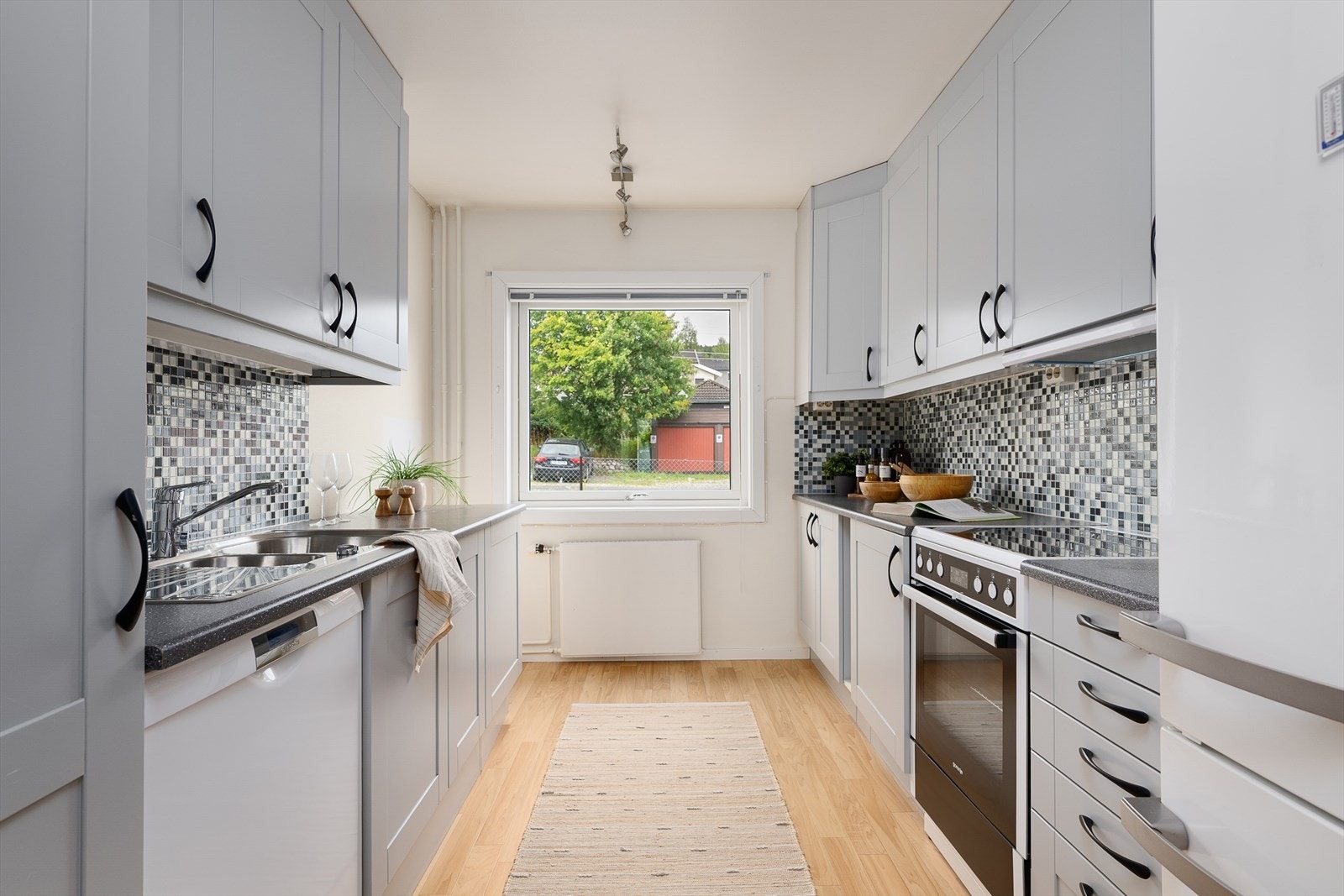 Lyst og funksjonelt kjøkken med vindu mot gaten. Godt med skap og benkeplass. Galleribilde