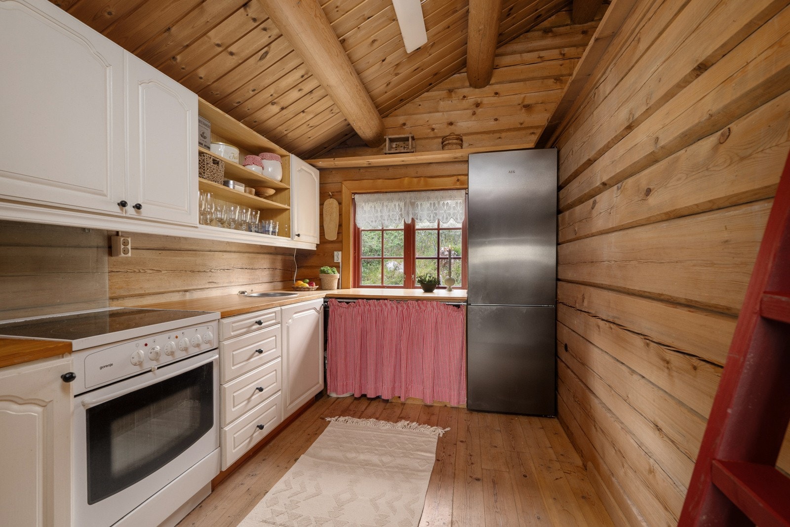 Kjøkkeninnredningen er pent utført med hvite, profilerte fronter og heltre benkeplate i eik med nedfelt kjøkkenkum. Galleribilde