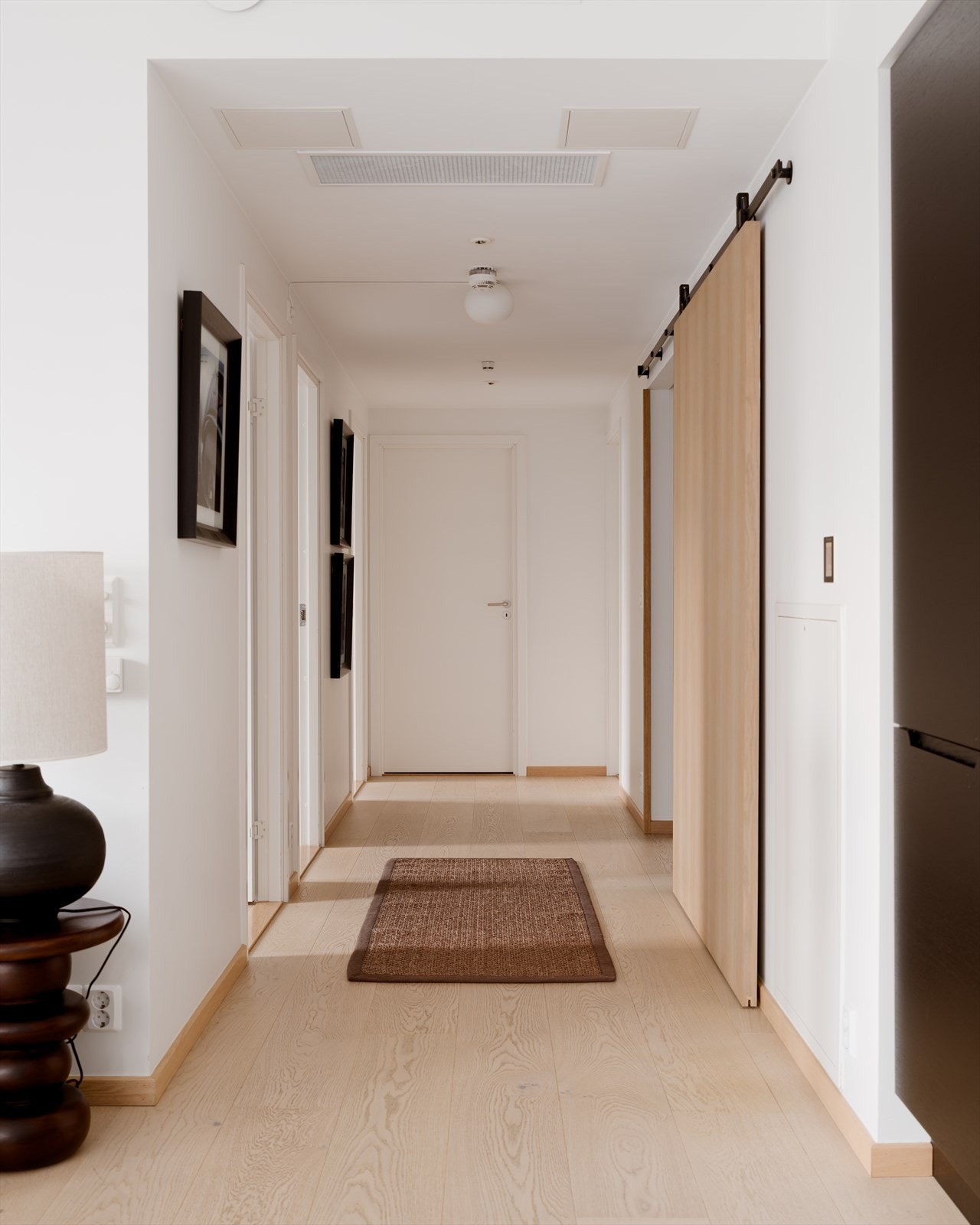 Entréen kan adskilles med skyvedør av massiv eik med utenpåliggende skinne i sortlakkert stål Galleribilde