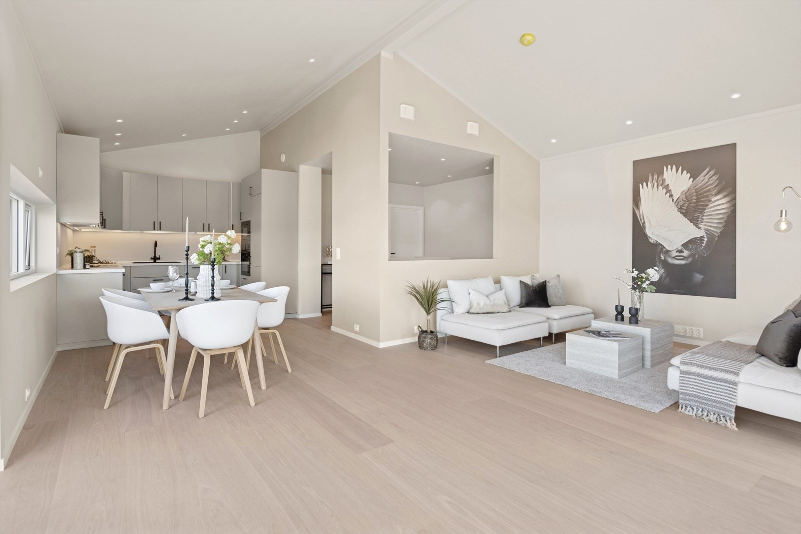 Stuen ligger med åpen løsning inn til det moderne kjøkkenet Galleribilde