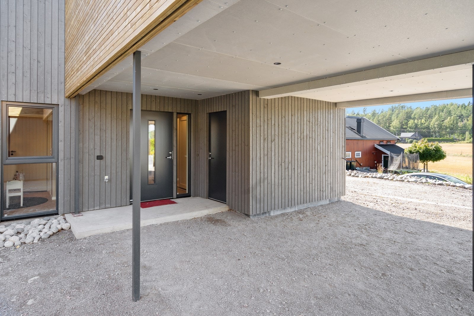 Overbygget inngangsparti med stor sportsbod rett på utsiden av inngangsdøren. Carport med plass til 1 bil, samt 1 til 2 biloppstillingeplasser utvendig. Galleribilde