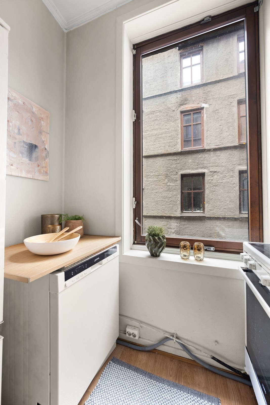 Kjøkkeninnredning med slette fronter, fliser på vegg over kjøkkenbenk og benkeplate i laminat. Galleribilde