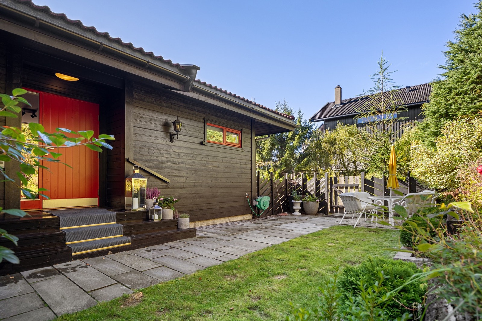 Privat inngangsparti med gressplen og opparbeidet bed. Galleribilde