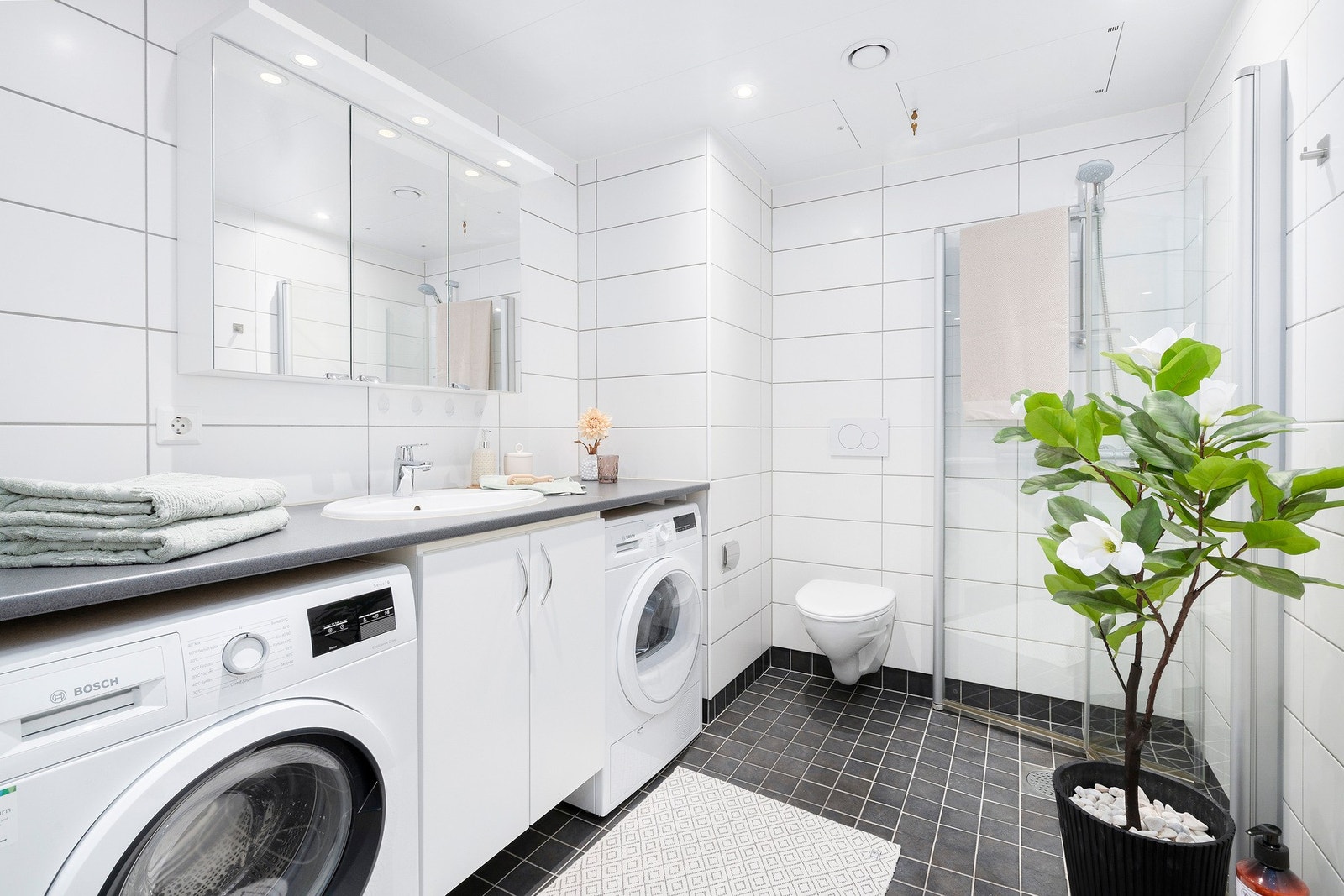 Moderne og helfliset baderom med varme i gulv og downlights i himling Galleribilde