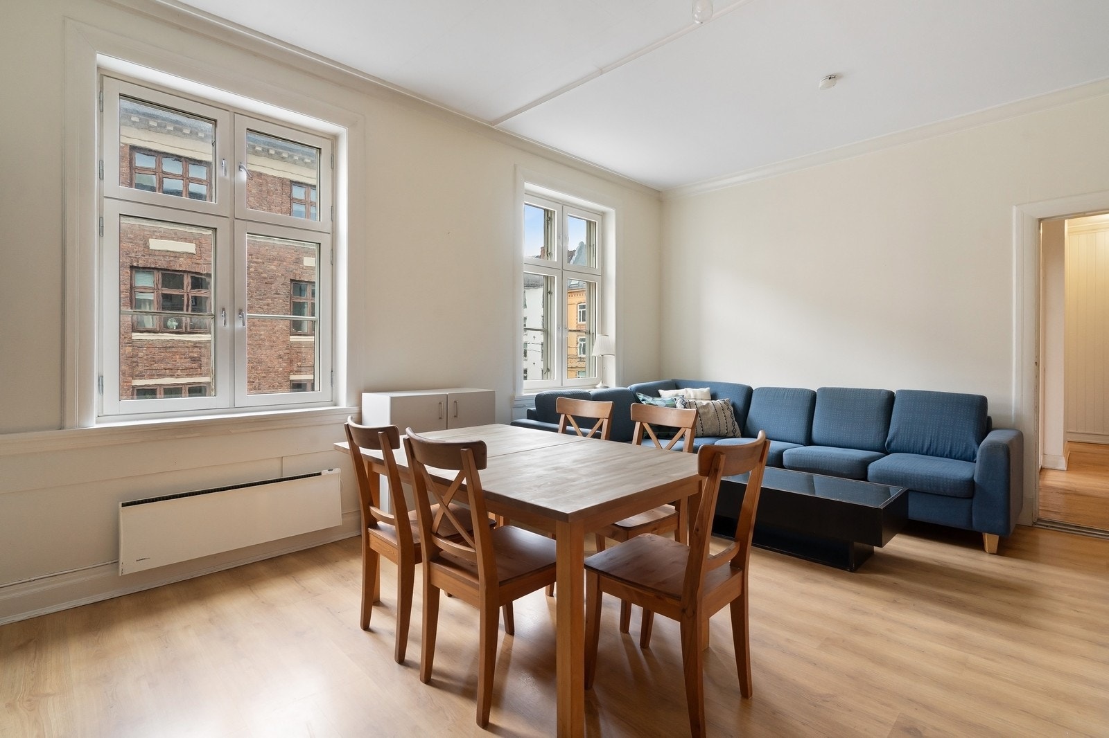 Kjøkken utgjør et romslig oppholdsrom med plass til stor sofa og spisebord. Galleribilde