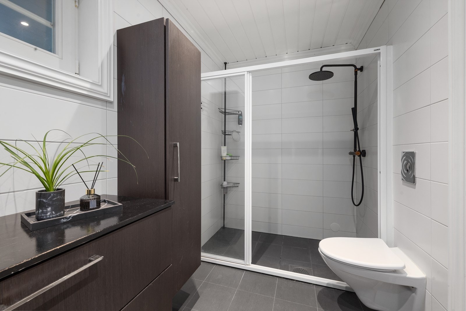 Rommet er utstyrt med to nedfelte servanter, veggmontert toalett og dusjhjørne. Galleribilde