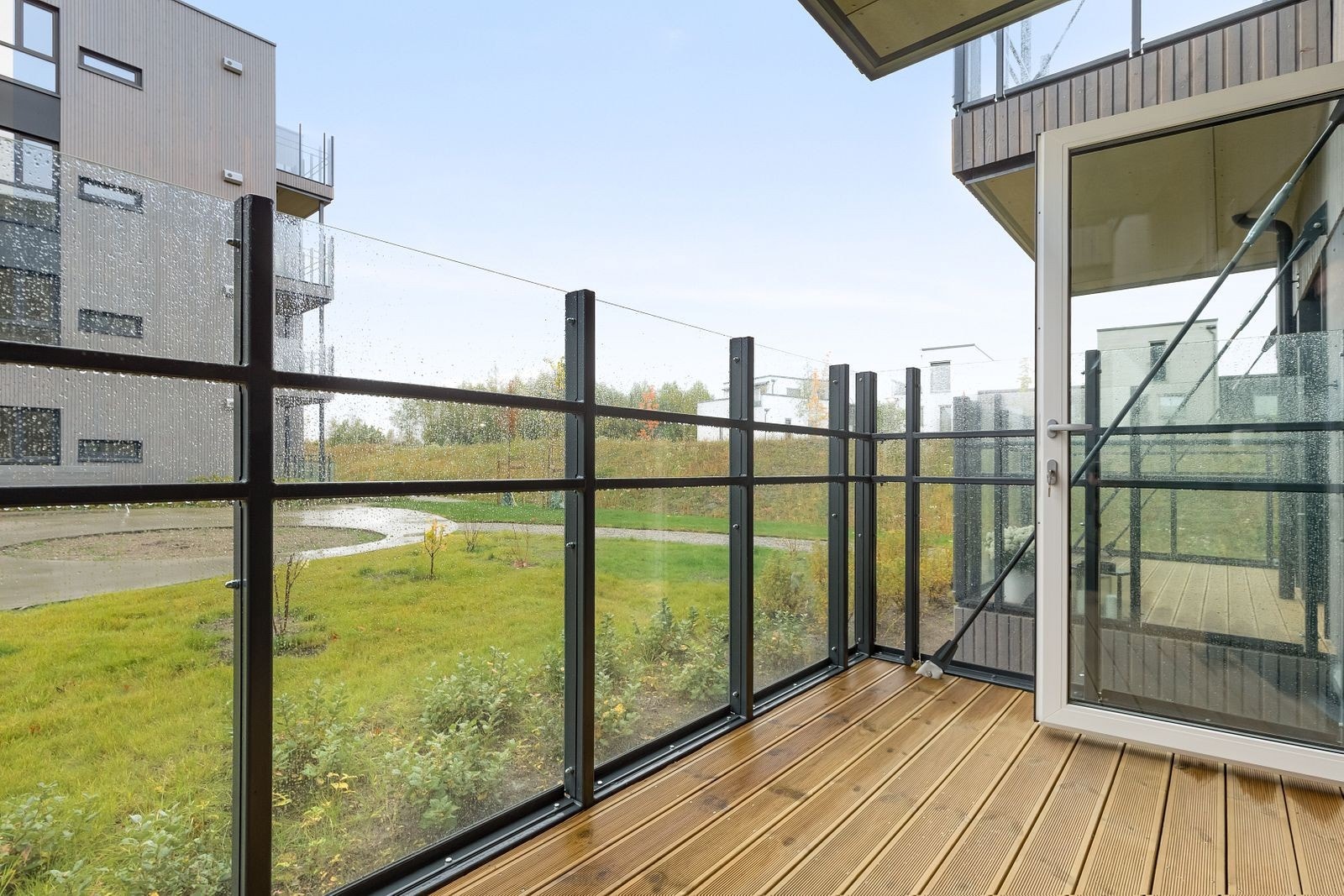 Hyggelig balkong med trelemmer og rekkverk i glass. Galleribilde