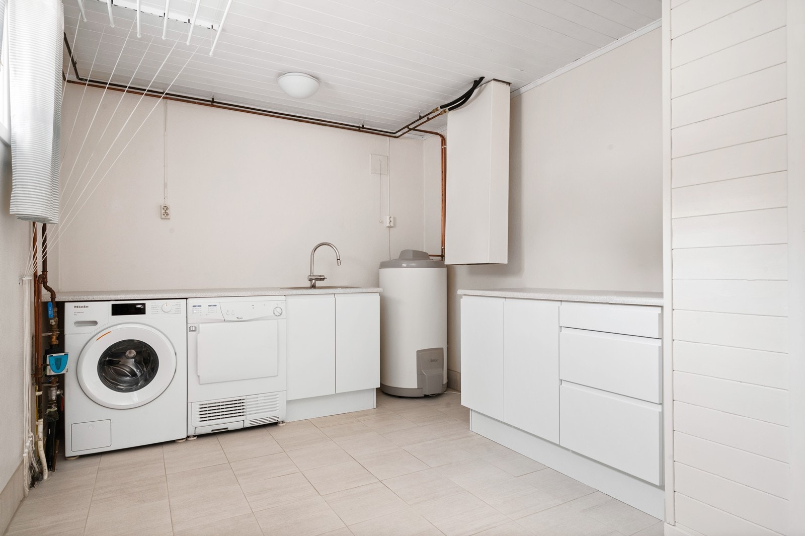 Separat og romslig vaskerom med flislagt gulv og god plass til innredning. Galleribilde