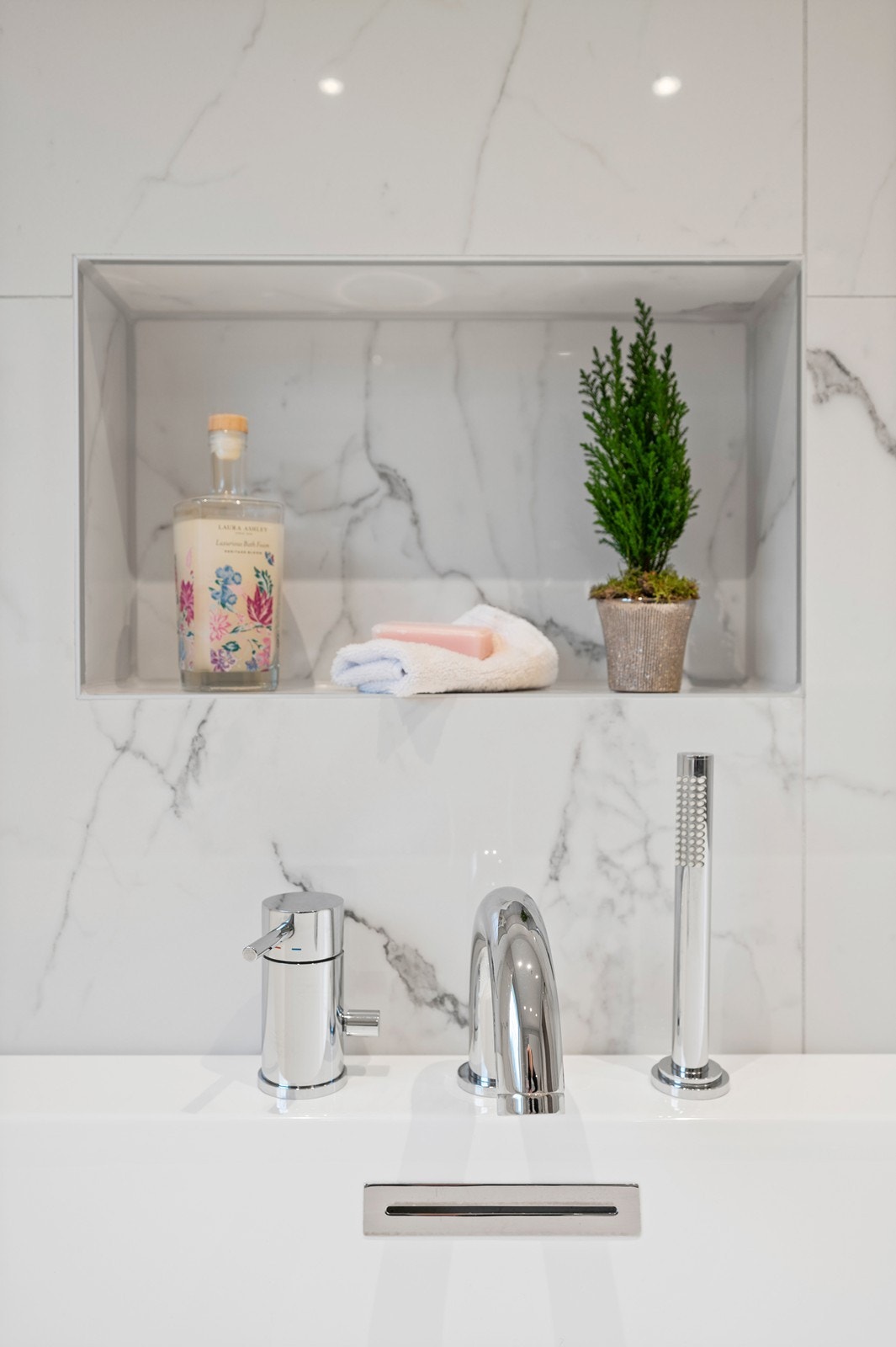 En praktisk og stilren nisje i veggen gir plass til oppbevaring ved badekaret. Galleribilde