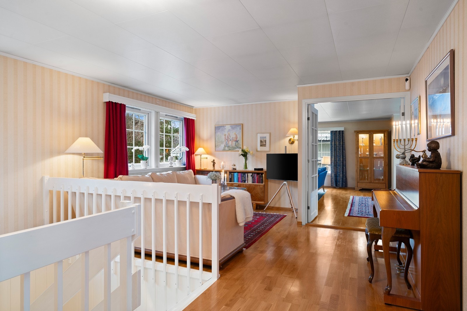 Første etasje åpner med en lys TV-stue som fungerer som et sosialt knutepunkt. Galleribilde