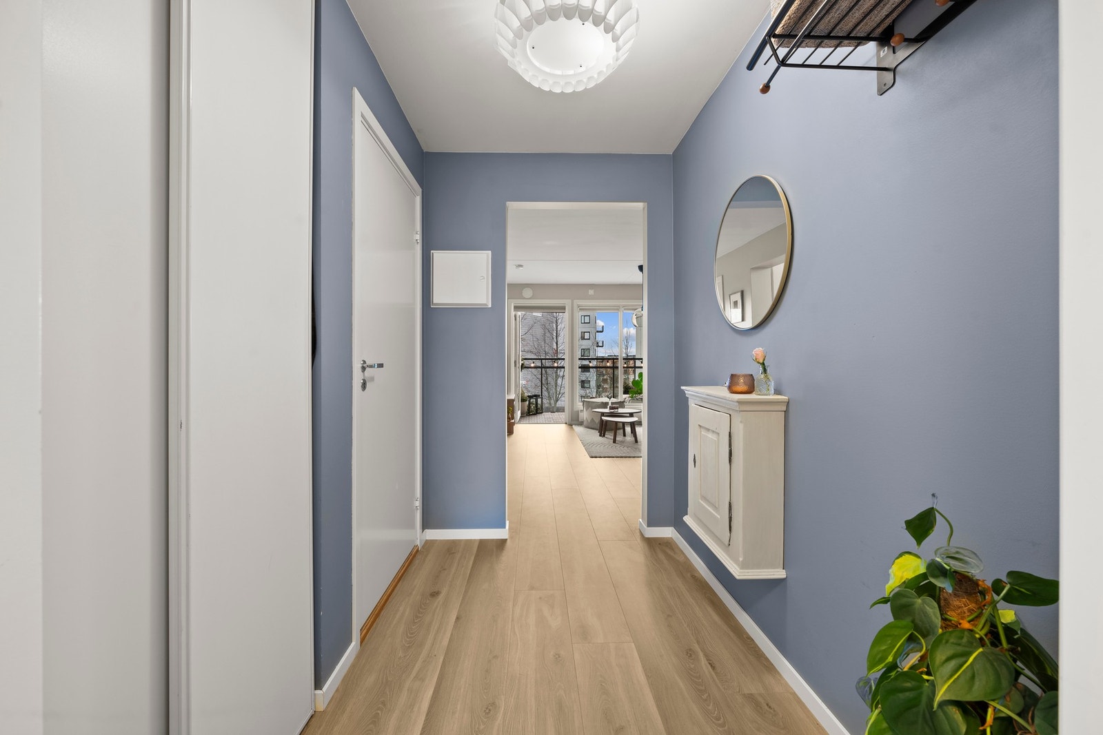 Gangen ble malt våren 2023 og fremstår lys og delikat, og de store vinduene i leiligheten slipper inn godt med naturlig lys som skaper en åpen og trivelig atmosfære. Galleribilde