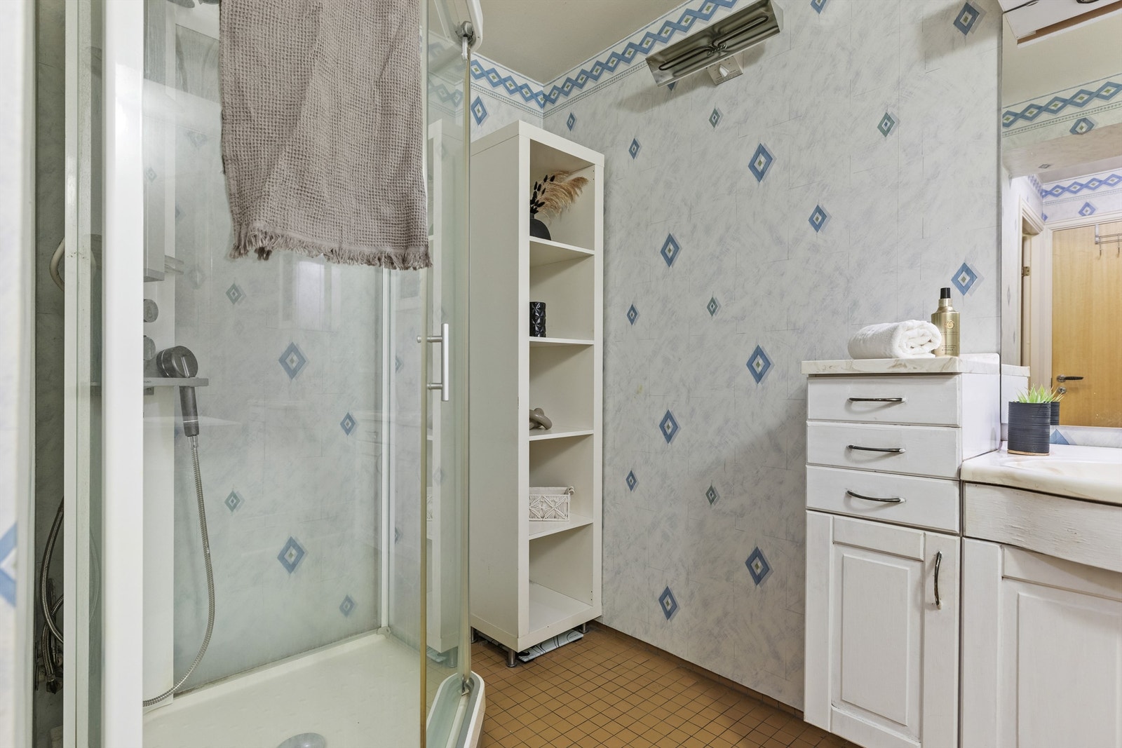 Badet er romslig og er flislagt på gulv med gulvarme og baderomstapet på veggene Galleribilde