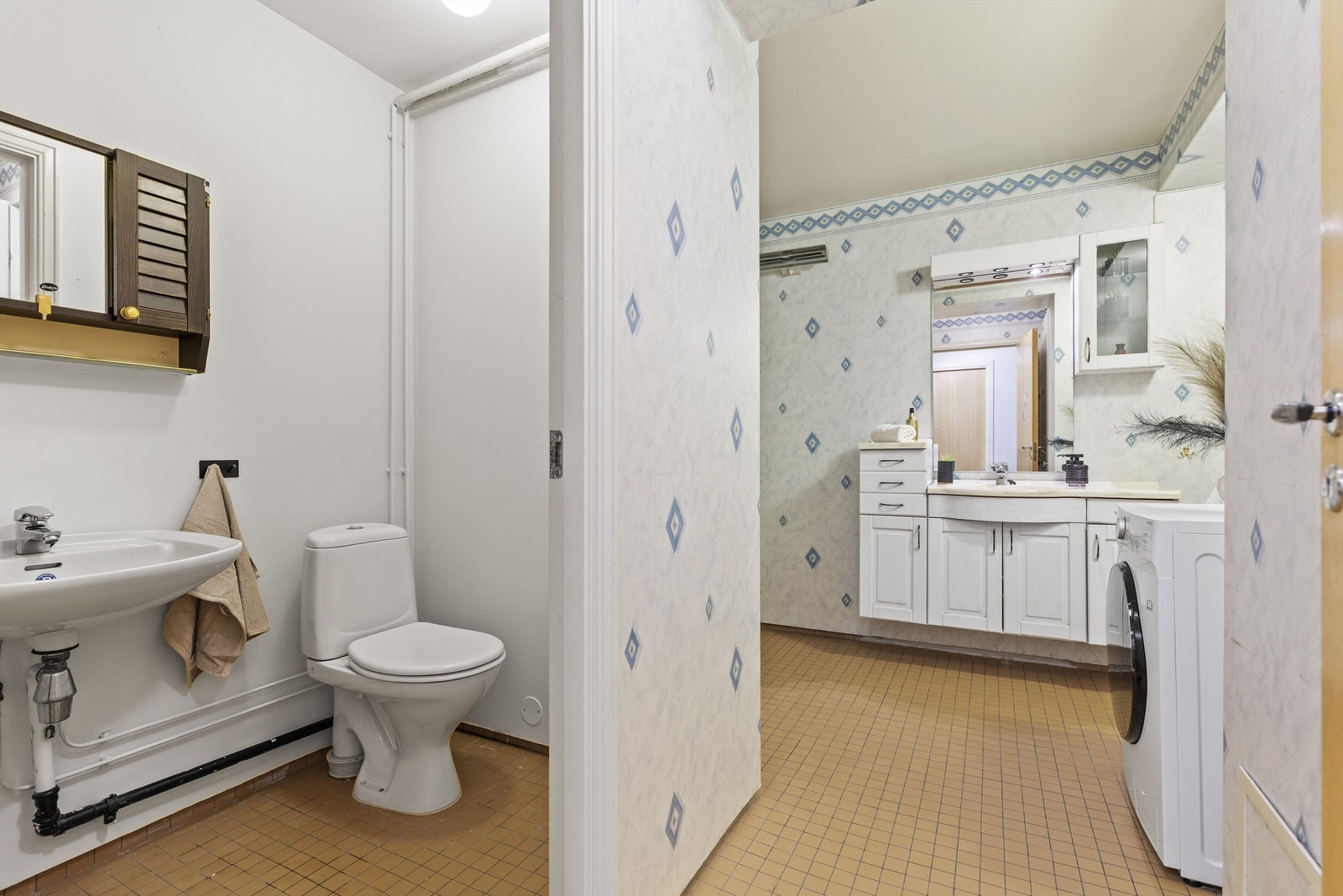 Badet har eget rom for toalett, med gulvstående toalett og servant med armatur Galleribilde