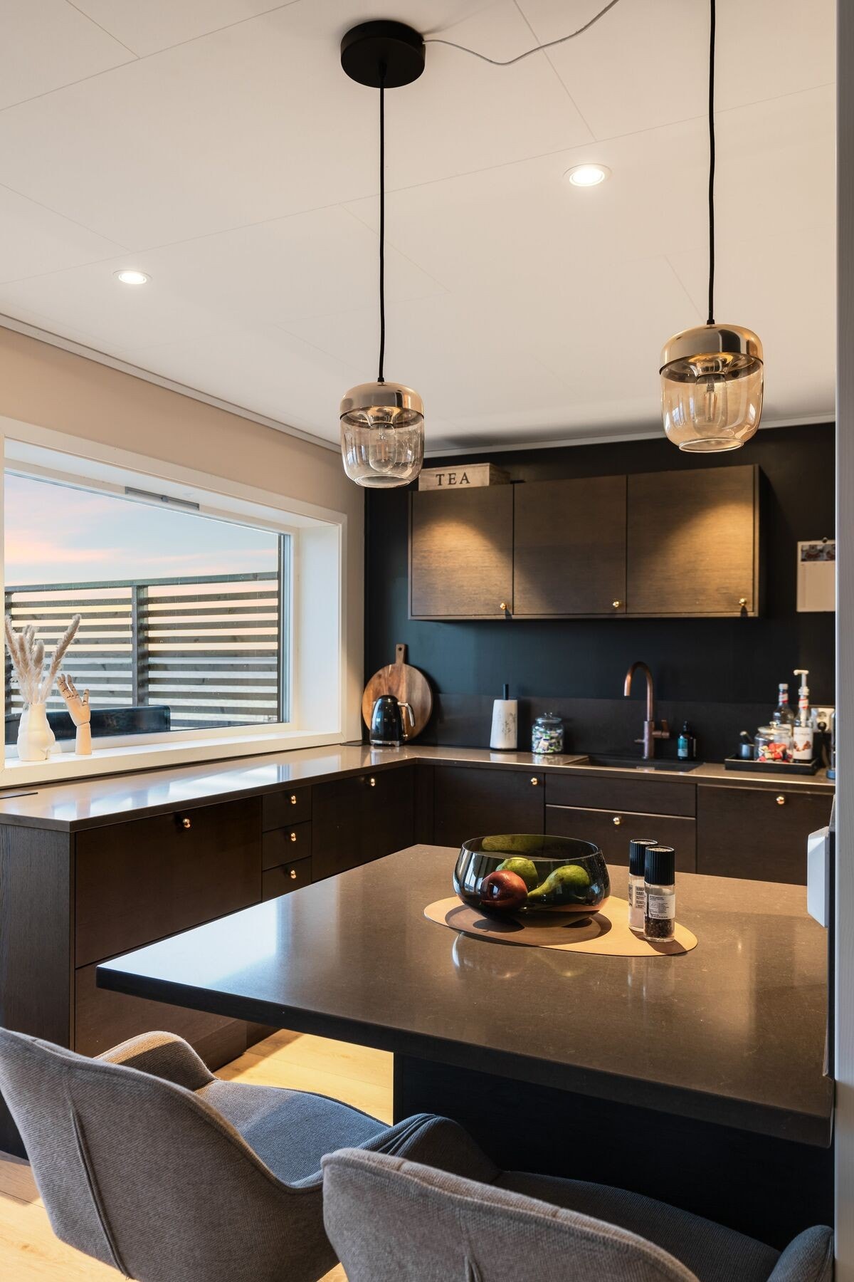 Kjøkkenet har kjøkkenøy/spisebord Galleribilde