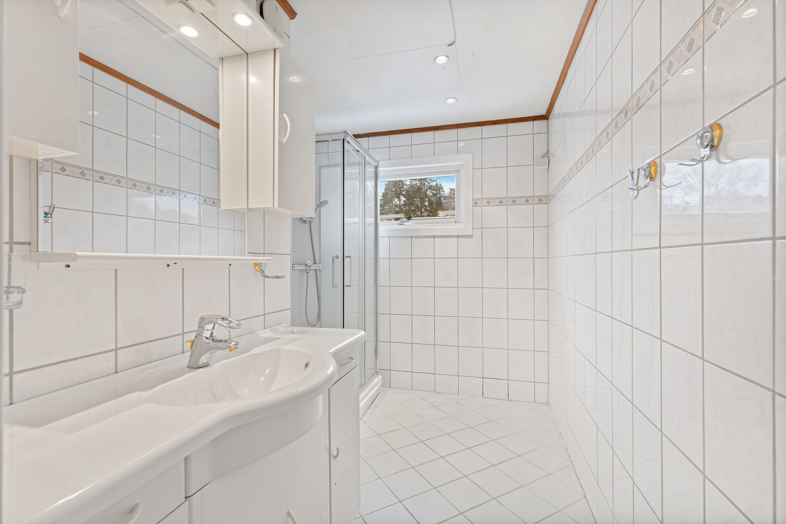 Innredningen består av servant med underskap, belyst speil med sideskap og dusjkabinett Galleribilde