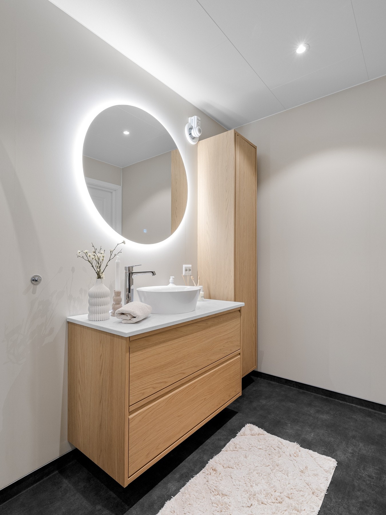 Badet er innredet med servantskap, høyskap og speil med belysning. Videre er badet utstyrt med dusjkabinett og toalett. Galleribilde