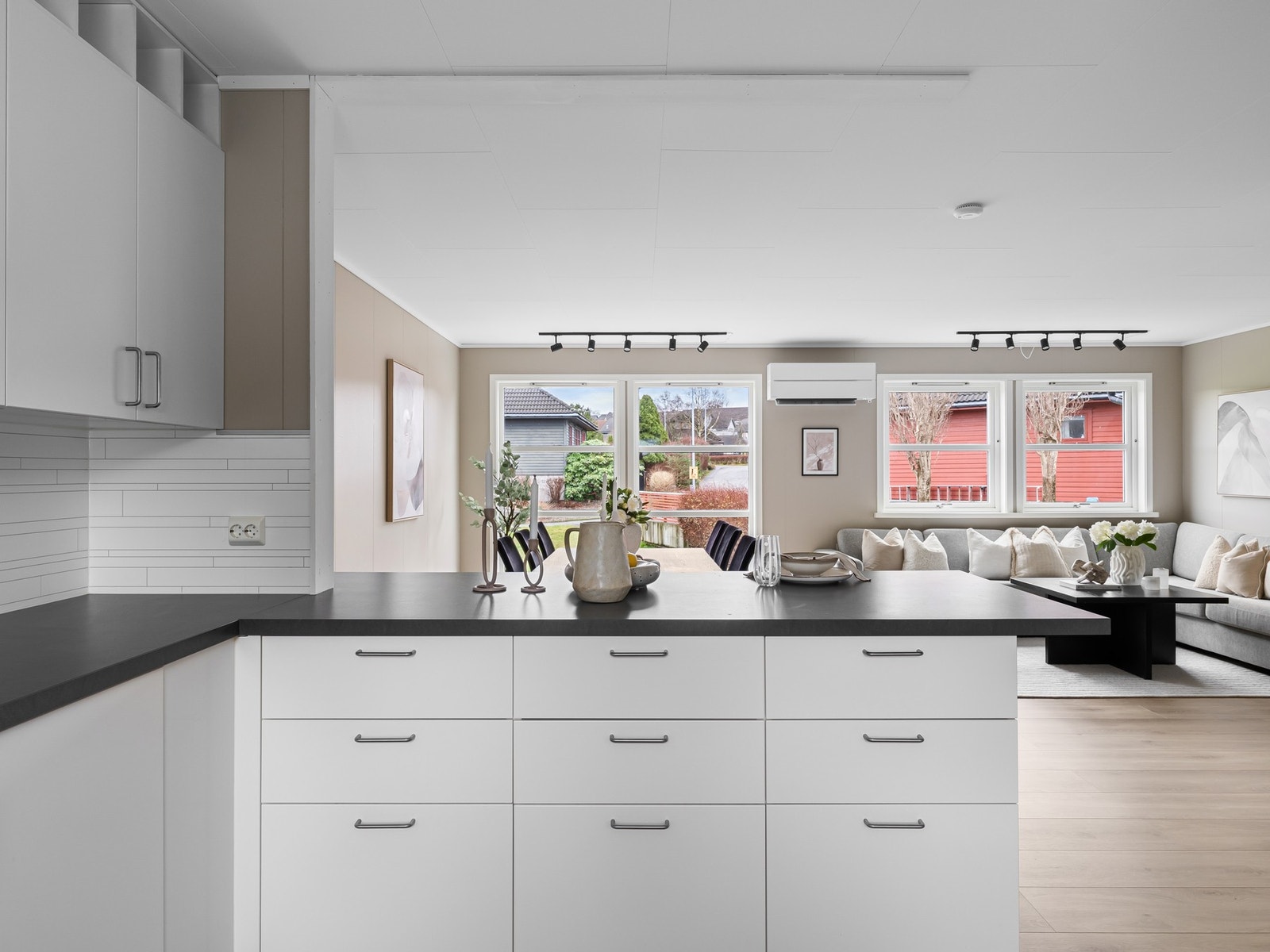 Kjøkkeninnredning med hvite slette fronter og benkeplate i laminat som er skiftet i 2015. Galleribilde