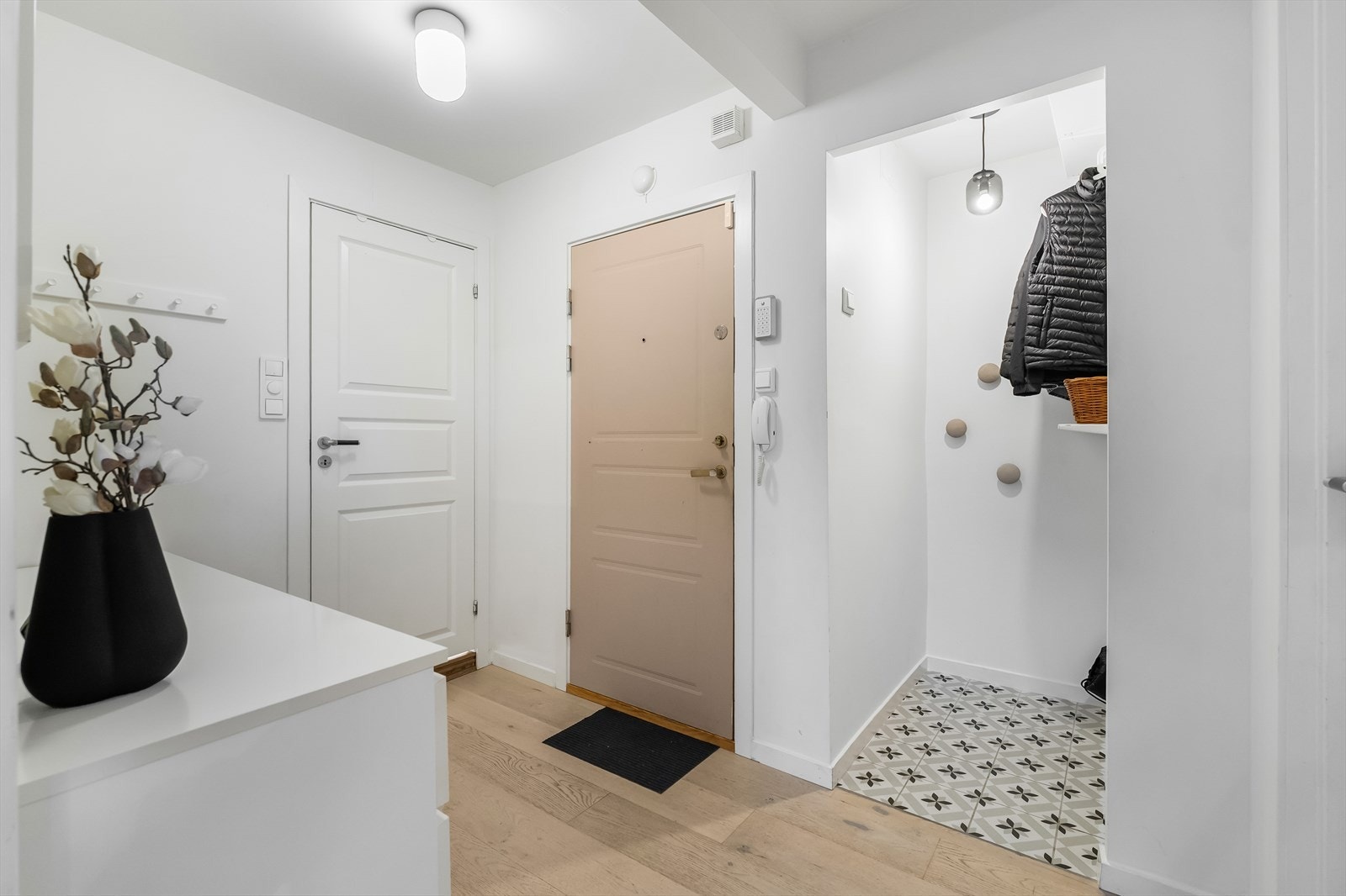 Entreen har 1-stavs laminatgulv fra senere år. Ved inngangsdøren er en porttelefon montert, og entreen har en praktisk separat garderobenisje. Galleribilde