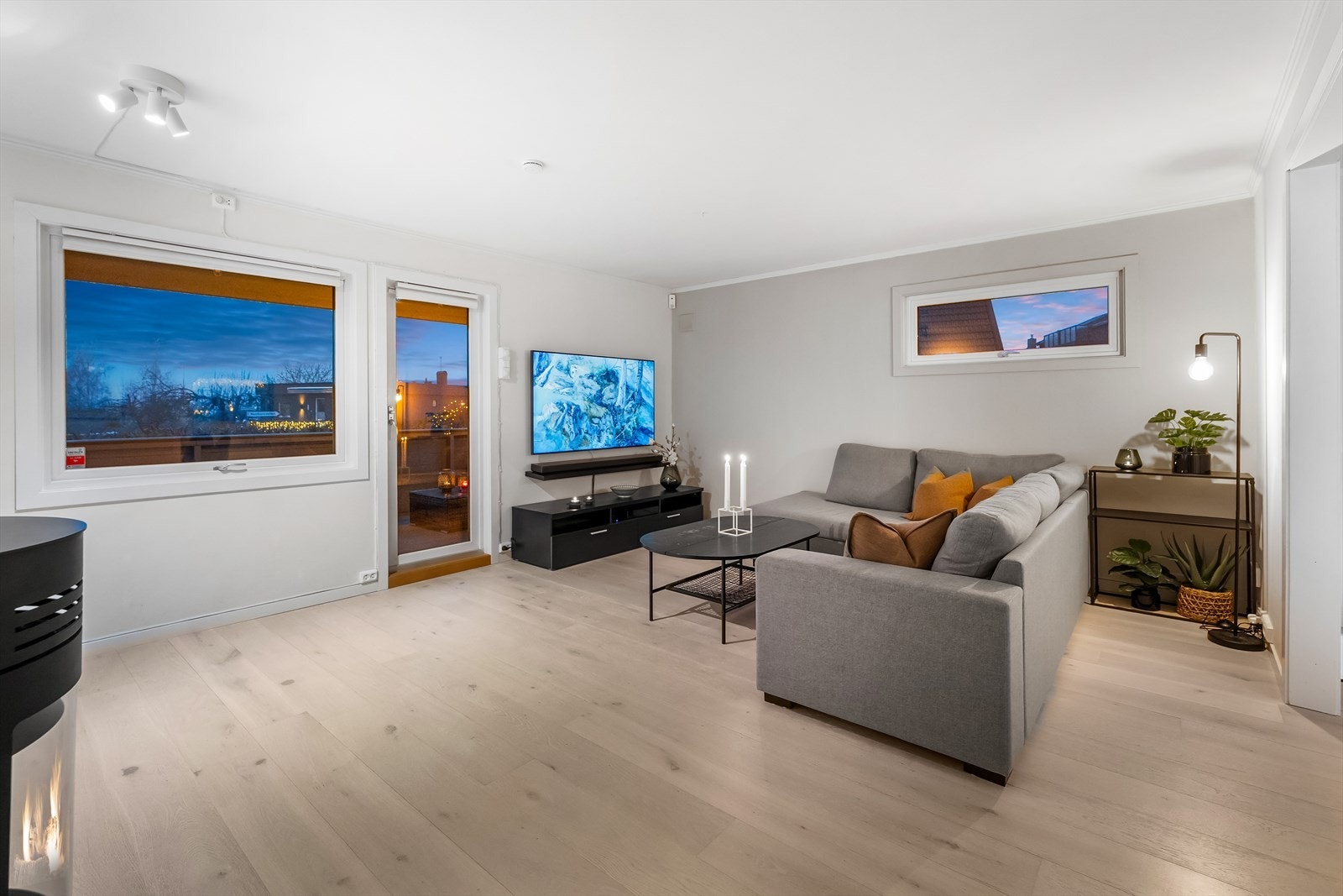 Entreen glir sømløst over i stuen, med det samme fine laminatgulvet. Stuen får naturlig lys fra to sider, og vinduene inkluderer en glassdør til den store terrassen. Galleribilde