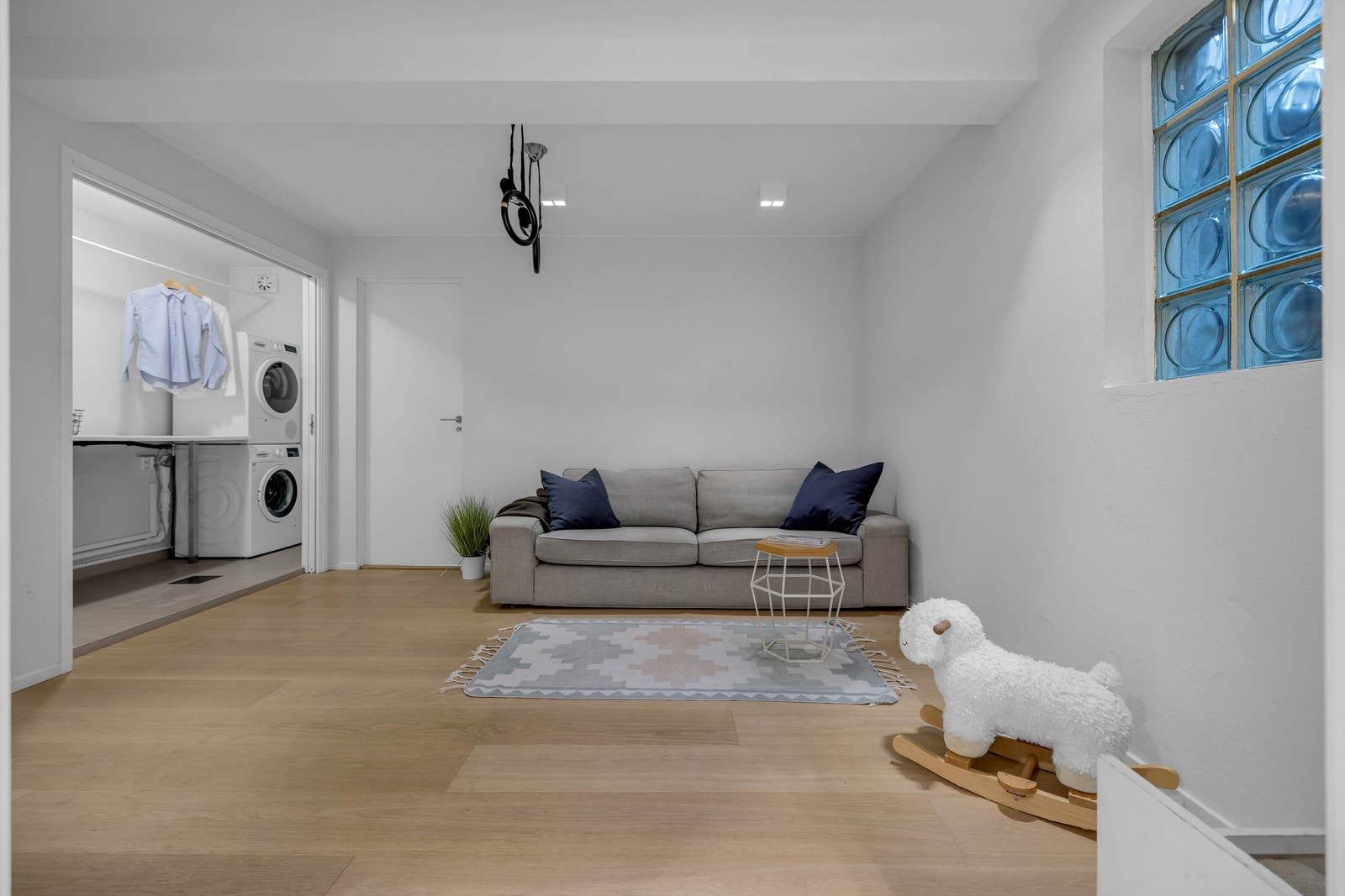 Smarte doble skyvedører skiller kjellerstuen fra husets vaskerom og fra gangen, for maksimal plassutnyttelse Galleribilde