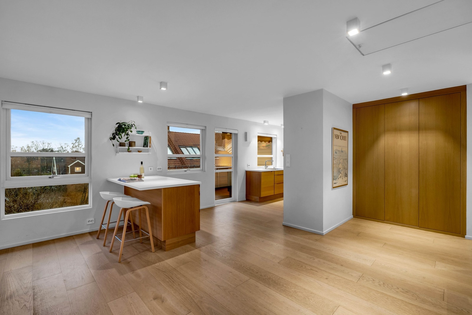 Det varme treverket går igjen i kjøkkeninnredningen, på gulvene, i trappetrinnene og i garderobeløsningene - noe som skaper en rød tråd gjennom hele huset. Galleribilde