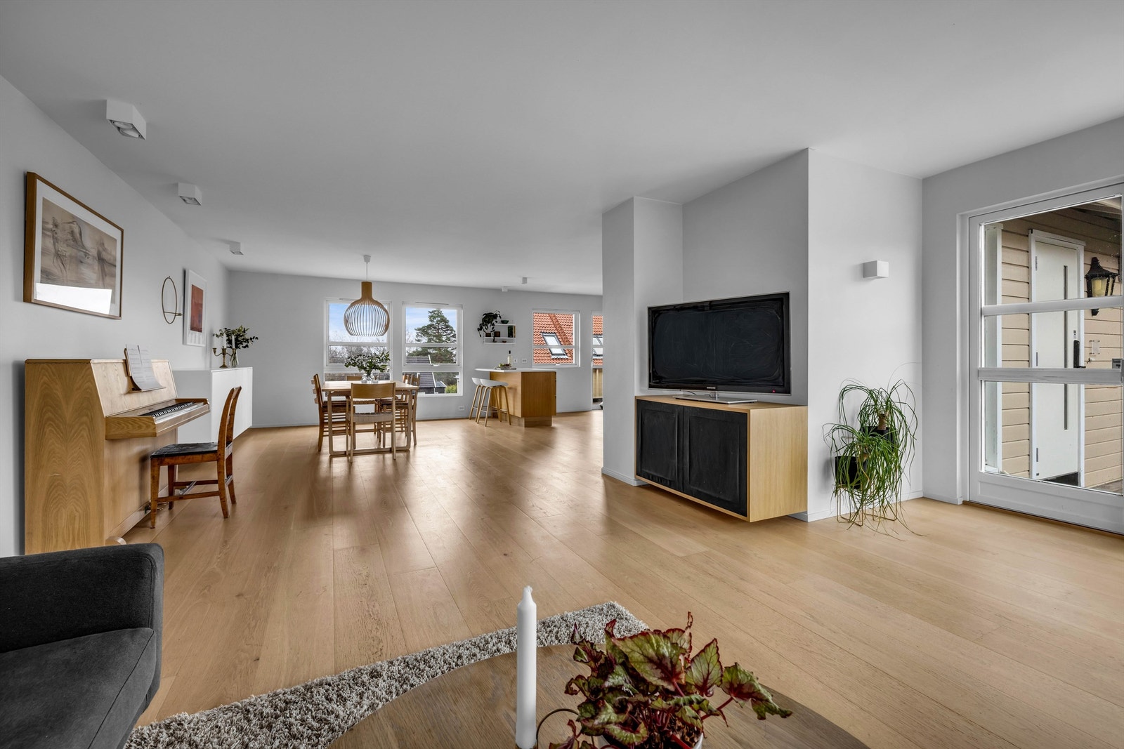 Det store, åpne oppholdsrommet danner boligens naturlige samlingspunkt og byr på en sjelden flott kombinasjon av kjøkken, spisestue og stue i en harmonisk helhet Galleribilde