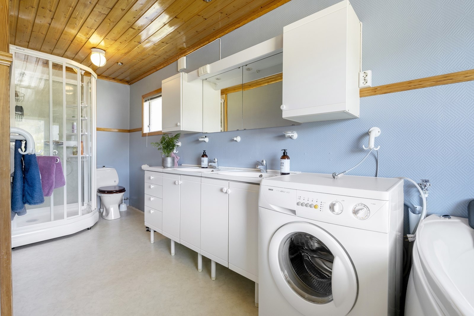 Bad med badekar, dusjkabinett og opplegg vaskemaskin Galleribilde