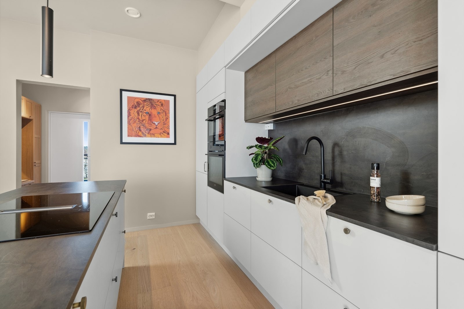 Med slette, hvite fronter gir det et rent og minimalistisk uttrykk som passer perfekt til resten av boligen. Galleribilde