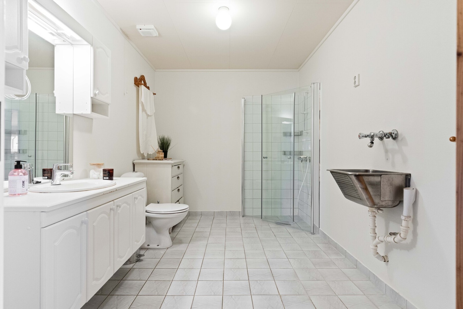 Her er det også vegghengt servantskap med nedfelt servant og ett-greps armatur, samt overskap og speil med overlys på vegg over servant. Videre er det en dusjnisje med innfellbare glassdører fra 2024, dusjarmatur og gulvmontert toalett. Det er også utslag Galleribilde