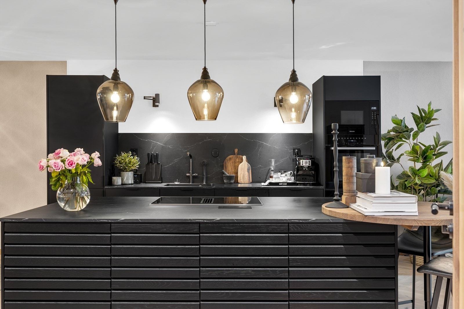 Den praktiske og sosiale kjøkkenøyen bidrar til godt med skap og benkeplass som gjør matlagingen til en lek. Galleribilde