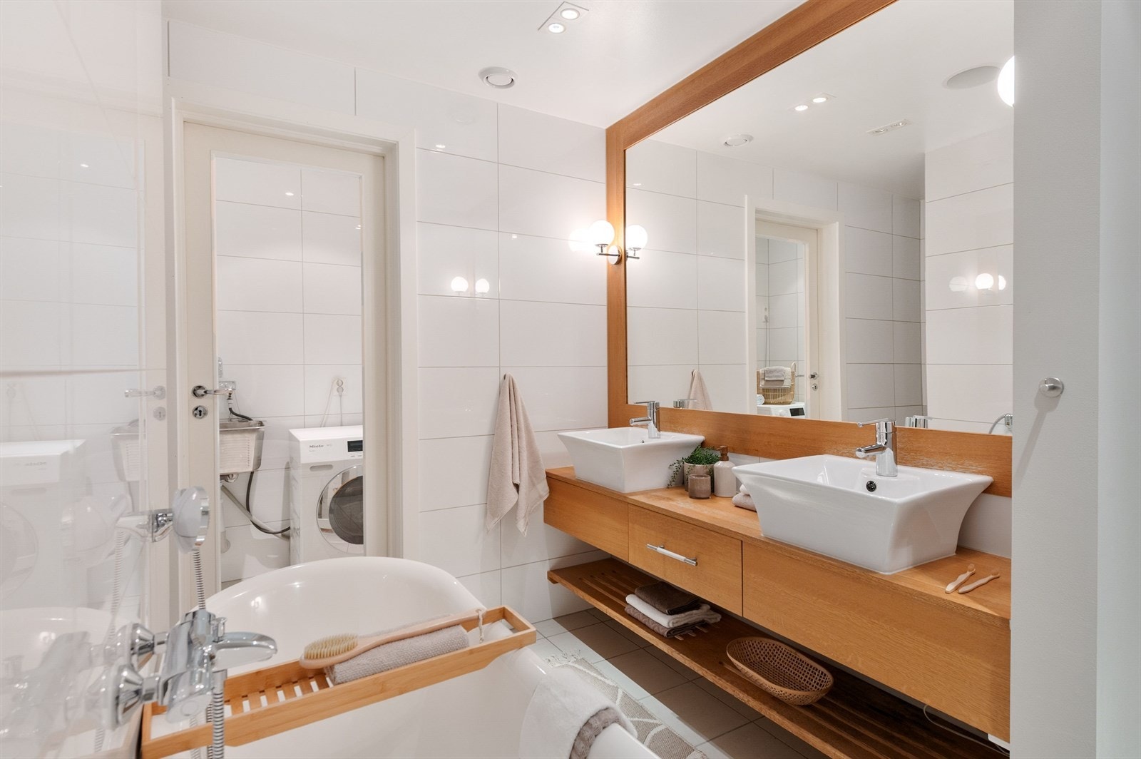 Praktisk og velfungerende baderom med dobbel servant, skapplass og direkte adkomst til vaskerom. Galleribilde
