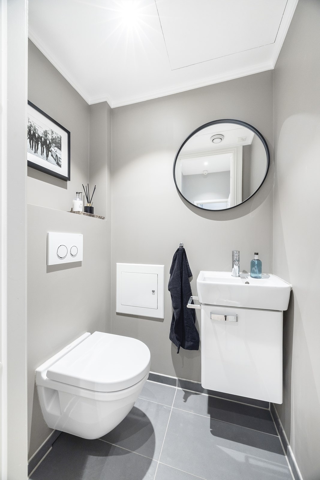 I tilknytning til hallen finnes et pent gjestetoalett med flislagt gulv og malte veggflater. Heldekkende servant på underskap, speil og vegghengt klosett. Galleribilde