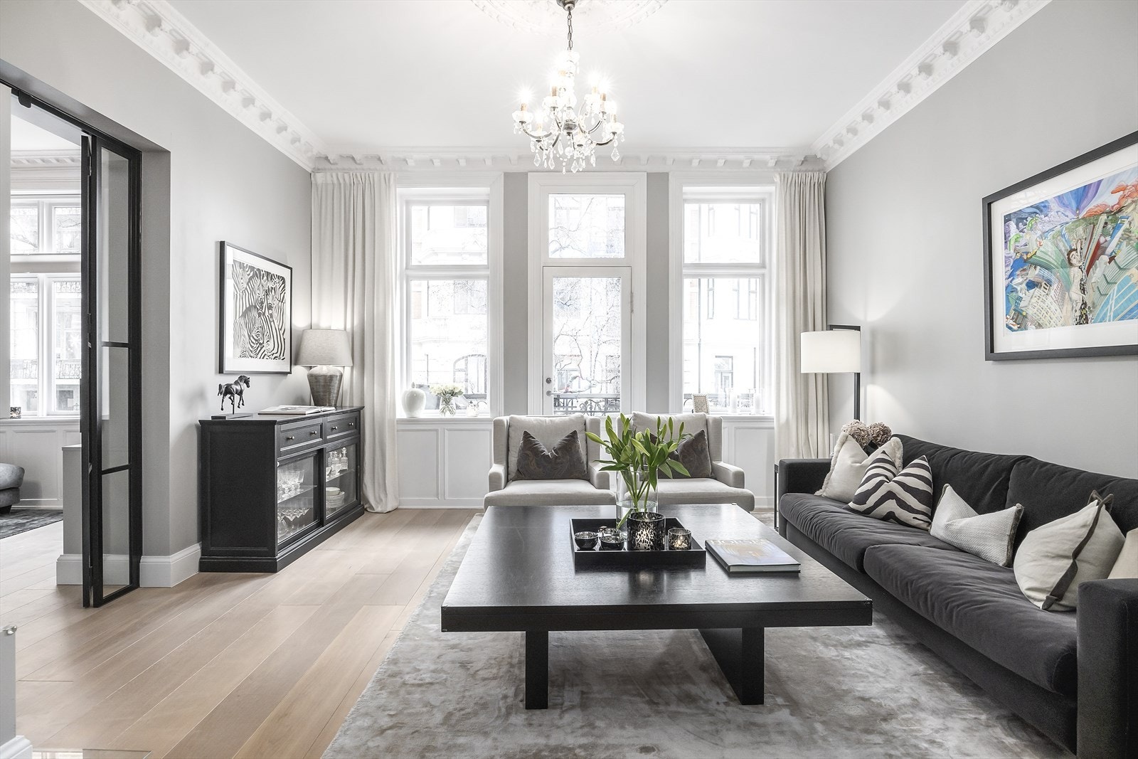 Boligen har to romslige stuer adskilt av en stilfull smijernsdør som skaper en elegant rominndeling. Galleribilde