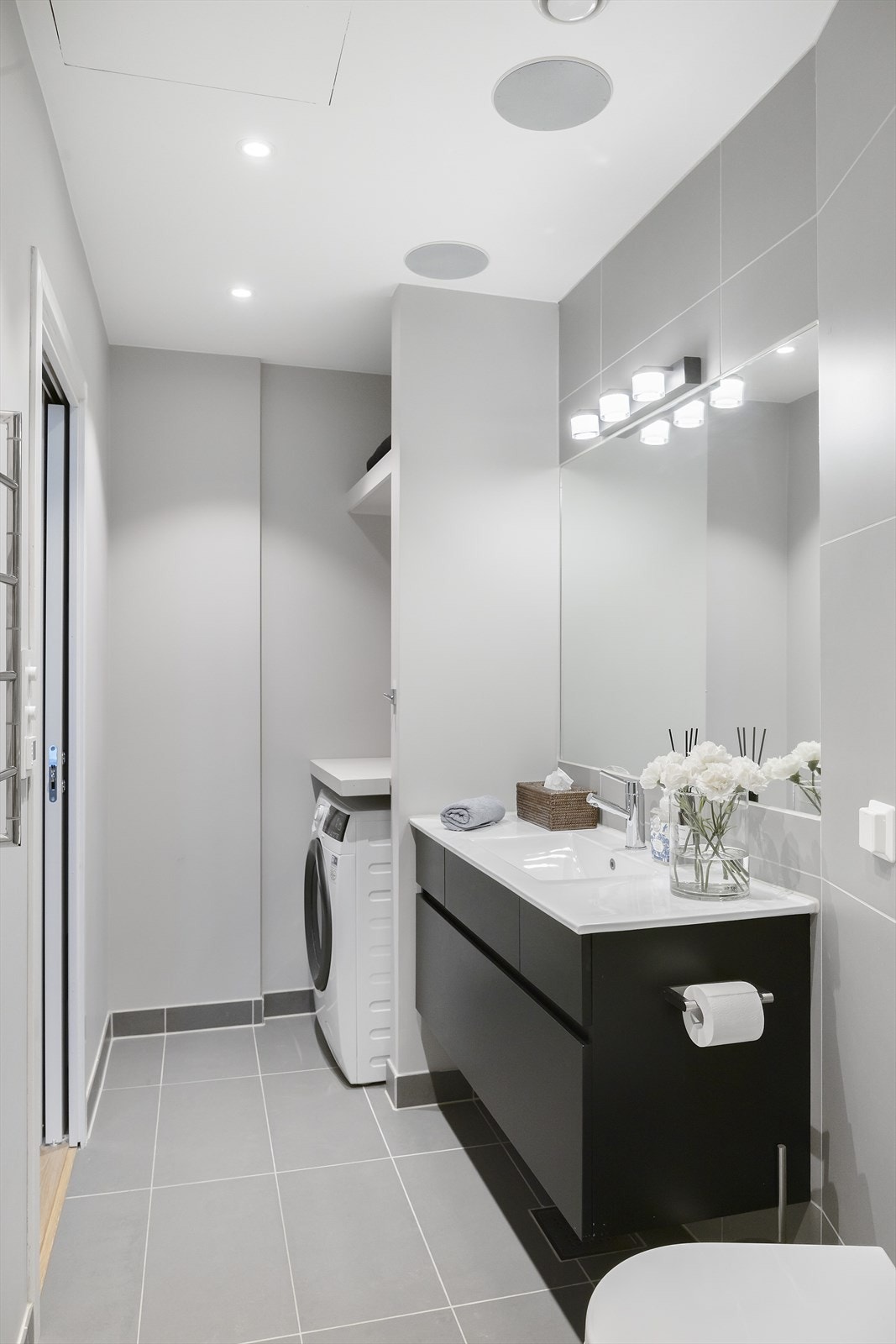 Flislagt bad med varmekabler i gulv. Heldekkende servant på underskap, speil og belysning. Vegghengt klosett og dusj med herdet glass. Opplegg for vaskemaskin. Galleribilde