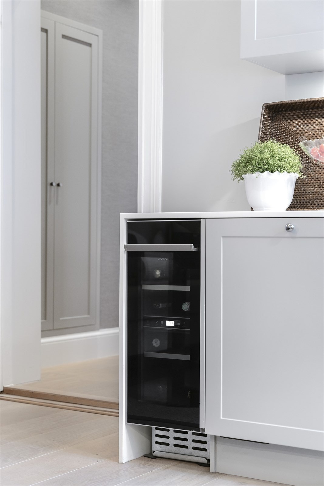 Integrerte hvitevarer bestående av kjøl/frys, oppvaskmaskin, stekeovn, induksjonstopp, mikrobølgeovn og vinkjøler. Galleribilde