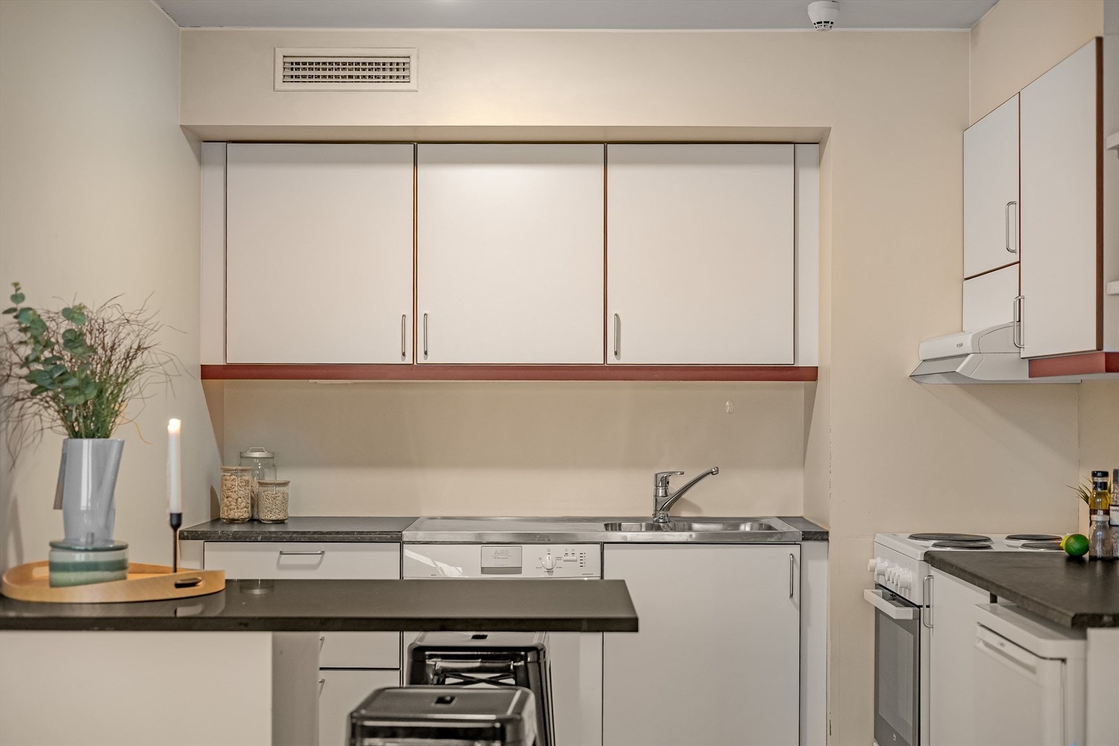 Hvit kjøkkeninnredning med en liten spiseplass Galleribilde