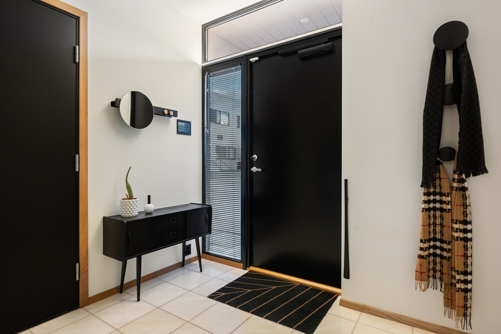 Flislagt gulv gir en praktisk og stilren entré med god plass for oppbevaring. Galleribilde