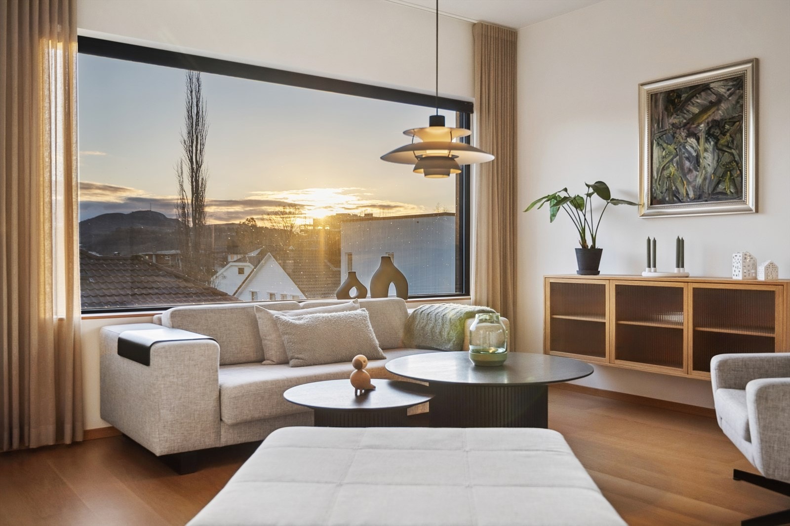 Stuen har parkettgulv og store vinduer som gir rikelig med naturlig lys og utsikt. Galleribilde