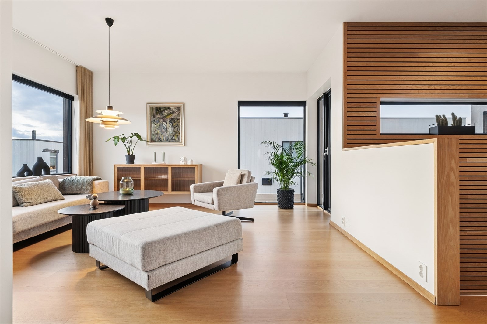 Store vindusflater gir rikelig med naturlig lys i stuen. Galleribilde