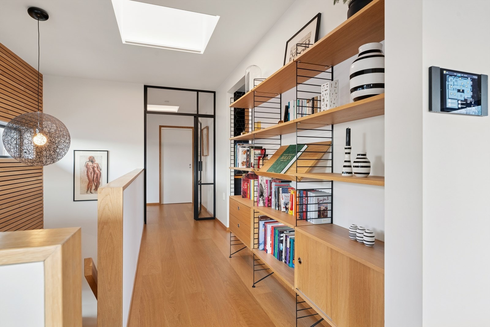 Veggene er kledd med spiler og malte plater, og gulvet er belagt med 1-stavs eikeparkett, som gir et moderne uttrykk. Galleribilde