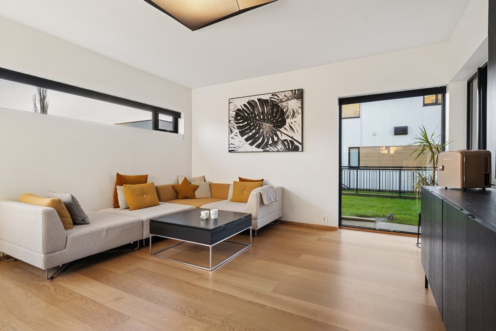 Parkettgulv og store vindusflater gir et lyst oppholdsrom. Galleribilde