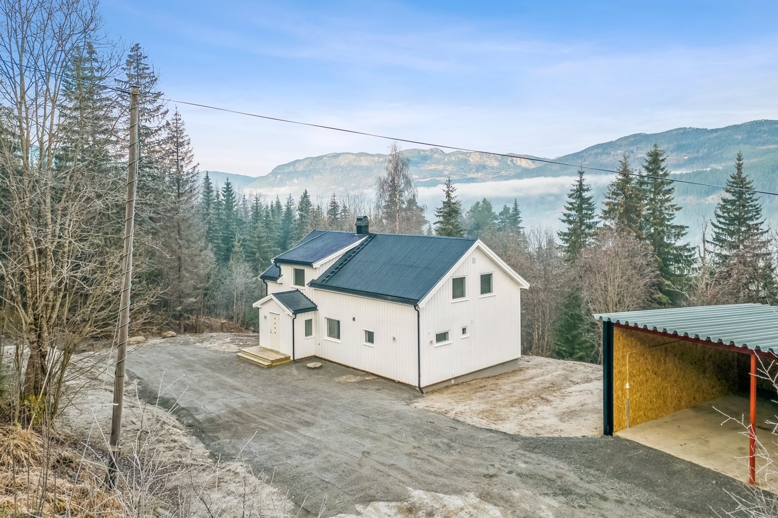 Stor gruset gårdsplass med uthus/ garasje. Galleribilde