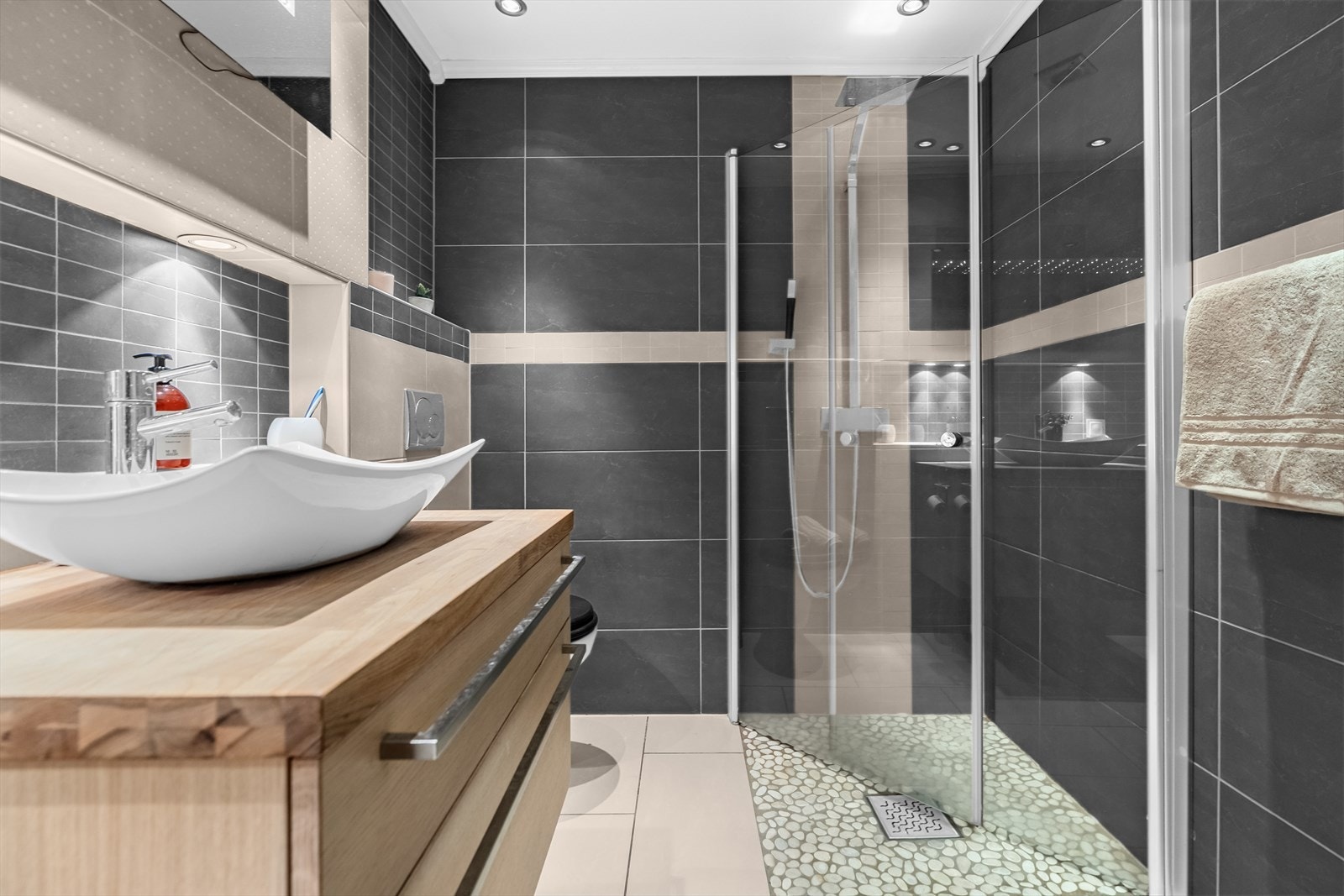 Delikat flislagt baderom med gulvvarme og downlights. Galleribilde