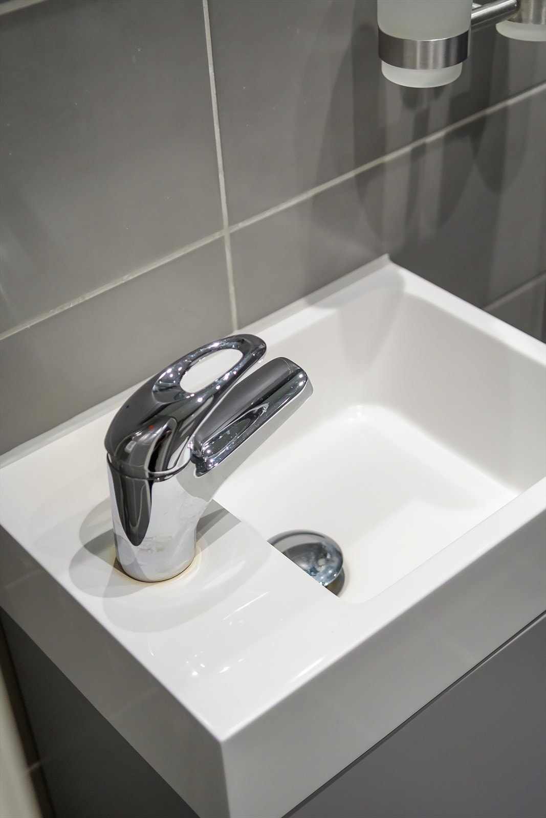 Badet er innredet med vegghengt toalett, innredning med nedsunket servant og speil og dusjhjørne med glassdører. Galleribilde