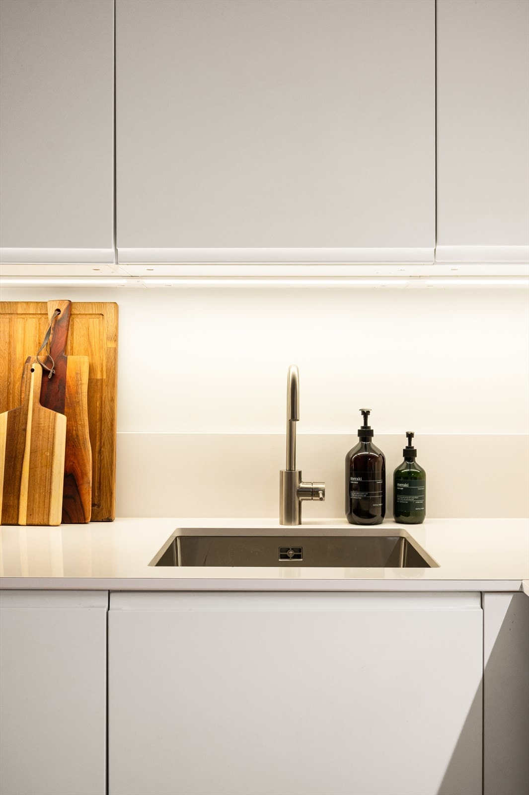 Kjøkkenet er utstyrt med innredning av glatte fronter og en solid benkeplate av stein med underlimt vaskekum. Galleribilde