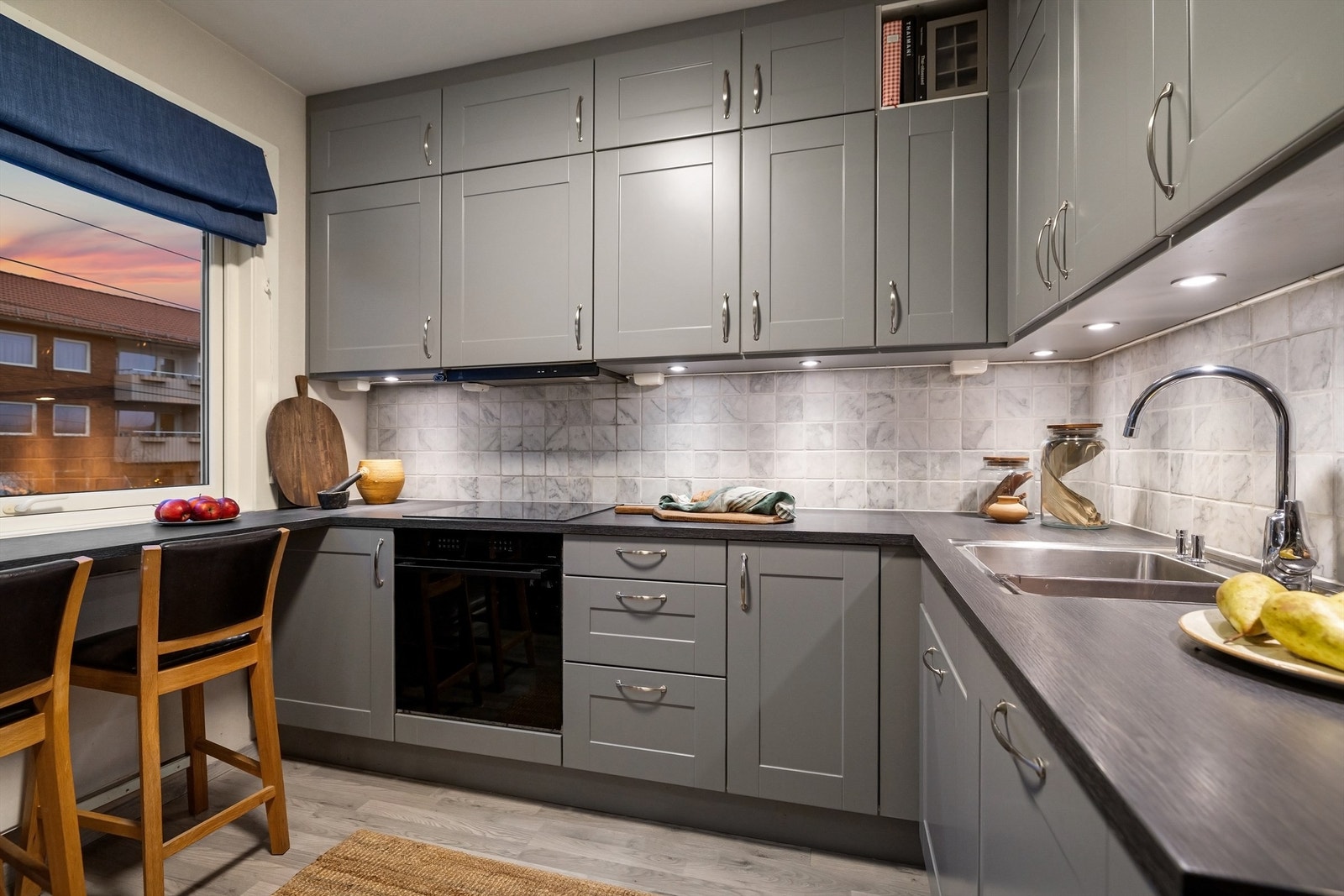 Kjøkkeninnredning fra HTH med profilerte fronter i grå utførelse, laminert benkeplate og underlimt oppvaskkum i rustfritt stål Galleribilde