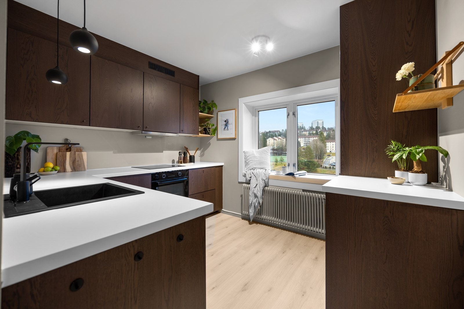 Fra entreen er det inngang til leilighetens separate kjøkken. Kjøkkenet har glatte fronter og en laminat benkeplate, med integrerte hvitevarer som kjøl/frys, komfyr, induksjonstopp og oppvaskmaskin. Galleribilde