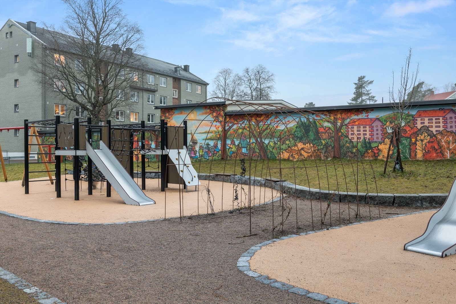 Pent opparbeidet tomt med plen, sittegrupper, internveier og nyere lekeplass. Galleribilde